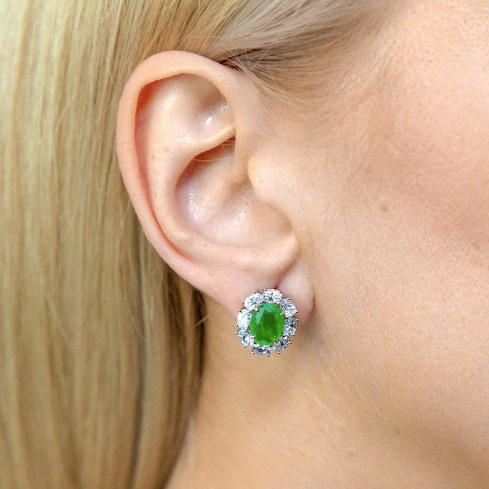 From the Victoria Collection by Anna Zuckerman Luxury, Sterling Silver Oval Emerald Green CZ Halo Stud Earrings. Classic 2 carat oval emerald green or sapphire blue crystalline stud with diamond white crystalline halo 8 tcw set in platinum plated sterling silver 925.