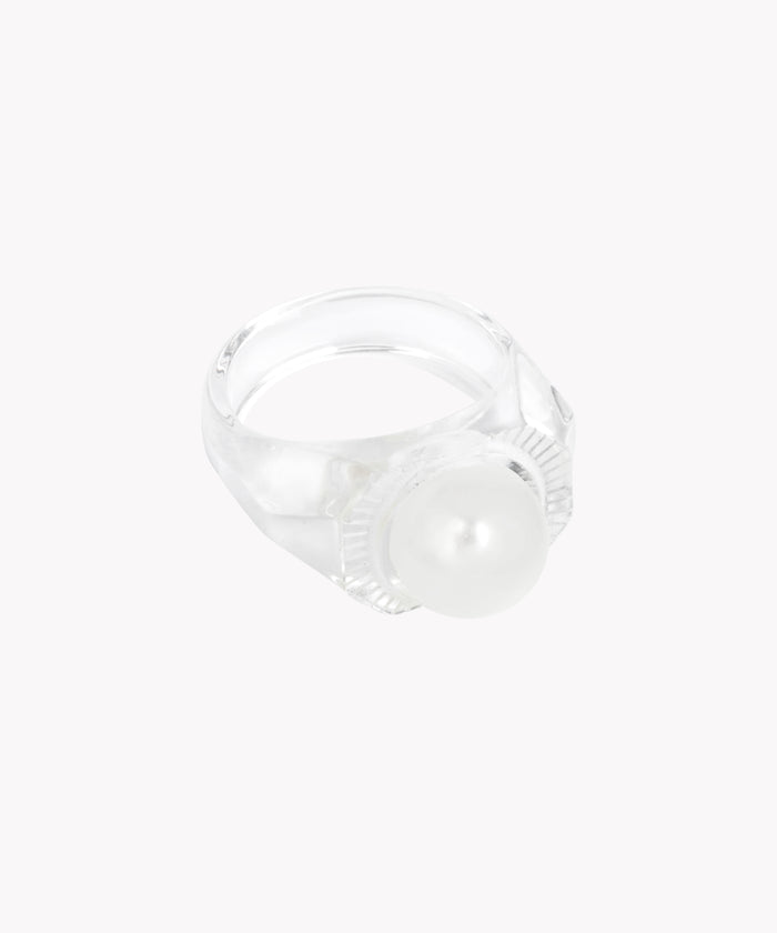 The Happy No No No Ring SAMPLE by WALD Berlin features a large Swarovski pearl accent on a transparent ring crafted from bio polyester. Made in Germany, it's set against a plain white background.