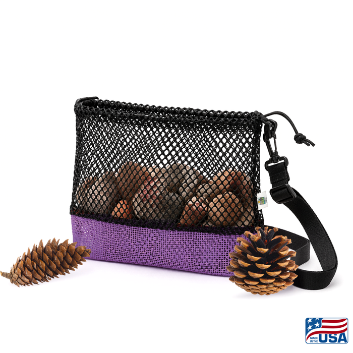 Purple and Black AdventureUs mesh collecting bag with carrying strap for agate hunting, rock collecting, mushroom foraging, and beachcombing. Filled with rocks with nature items around for featured suggested use.