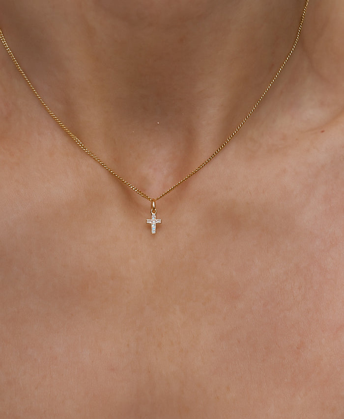 Halsband med ett litet diamantkors i guld.