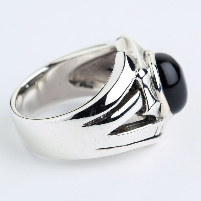 Side profile showing the thick polished sterling silver band and smooth black stone resting in a heavy structural setting.