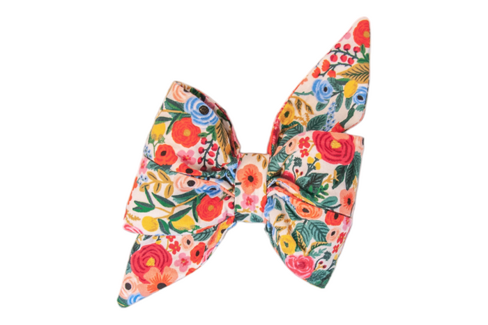 Bright and cheerful, this floral girl dog belle bow is a burst of springtime joy in shades of pinks, blues, greens, yellows.