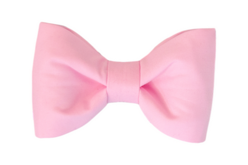 A classic soft pink dog bow tie with a symmetrical shape and smooth fabric texture, centered against a white background.
