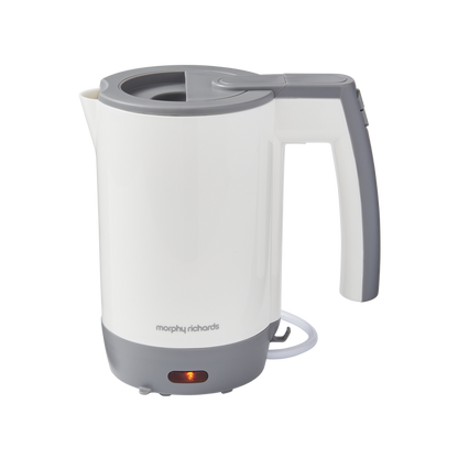 A white Morphy Richards compact travel kettle with a gray handle and base, featuring a boil-dry protection switch and a power indicator light.