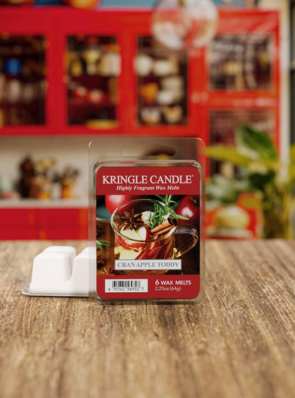 Kringle Candle cran apple spice wax melts packaging on a wooden surface with a blurred store background.