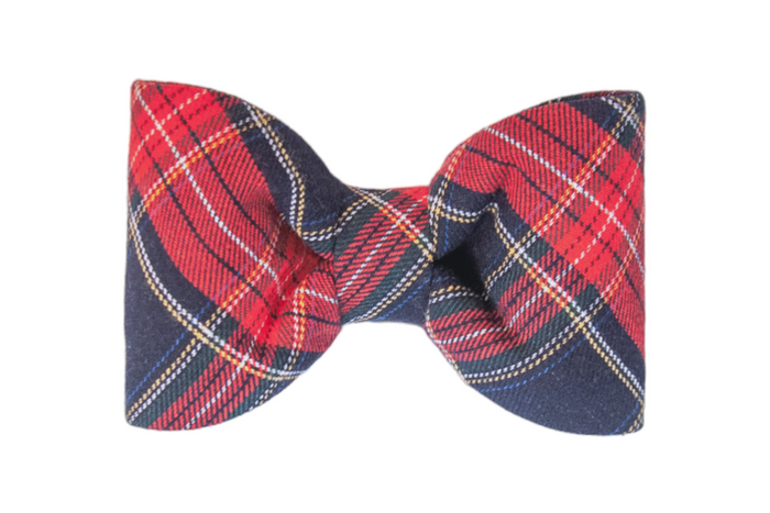 Classic-style bow tie in a bold red tartan fabric, featuring crisscrossing light lines. The bow tie is neatly balanced, rounded wings and a centered cinched knot, designed for a clean and timeless look.