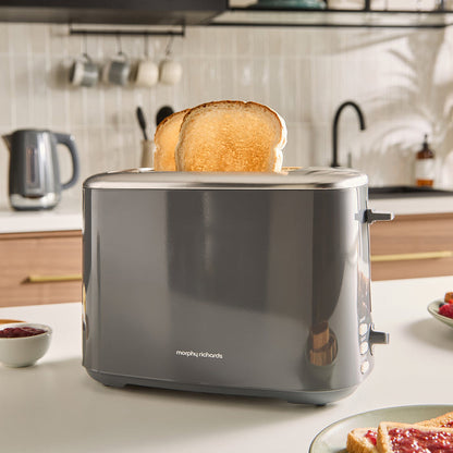 Grey toaster with a slice of toast on a kitchen counter