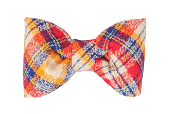A classic dog bow tie made from soft flannel in a vibrant plaid pattern. The bow tie is neatly structured with symmetrical loops and a cinched center, offering a timeless fall-inspired accessory for a dog collar.