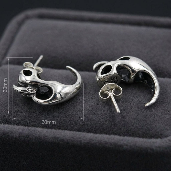 Sterling silver flame claw stud earrings with skull-inspired hollow design featuring curved talon shape, displayed on dark gray velvet jewelry box with 20mm dimensions shown, gothic biker style accessories
