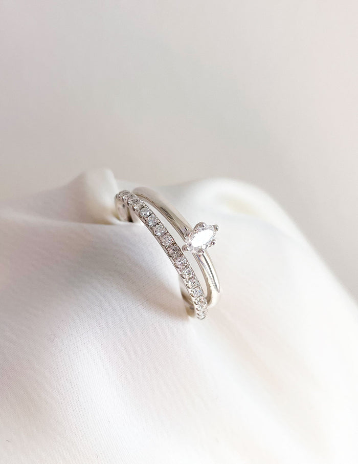 Set med två diamantringar. Alliansring med ett band av diamanter och en enstensring med en oval diamant.
