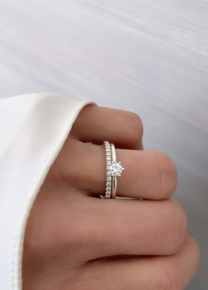 Tjej som bär ett set med vigsel- och förlovningsring med diamanter.