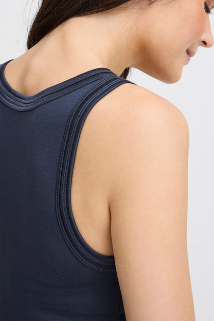 Navy blue sleeveless top worn by a person on a light gray background