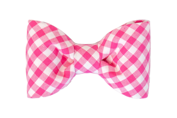Dog bow tie in a vibrant fuchsia and white plaid print, designed with crisp pleats and rounded edges. The classic check pattern adds a playful yet polished touch, ideal for special events or daily wear.