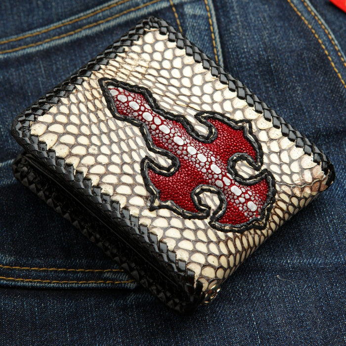 The exotic leather wallet with a red cross resting on denim jeans, showcasing its unique materials.