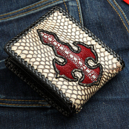 The exotic leather wallet with a red cross resting on denim jeans, showcasing its unique materials.