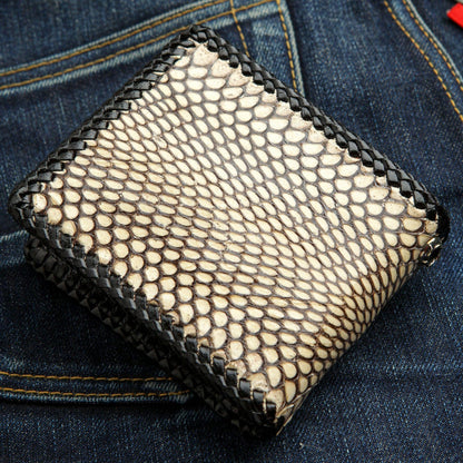A handcrafted cobra skin wallet with detailed black leather lacing on the edges.