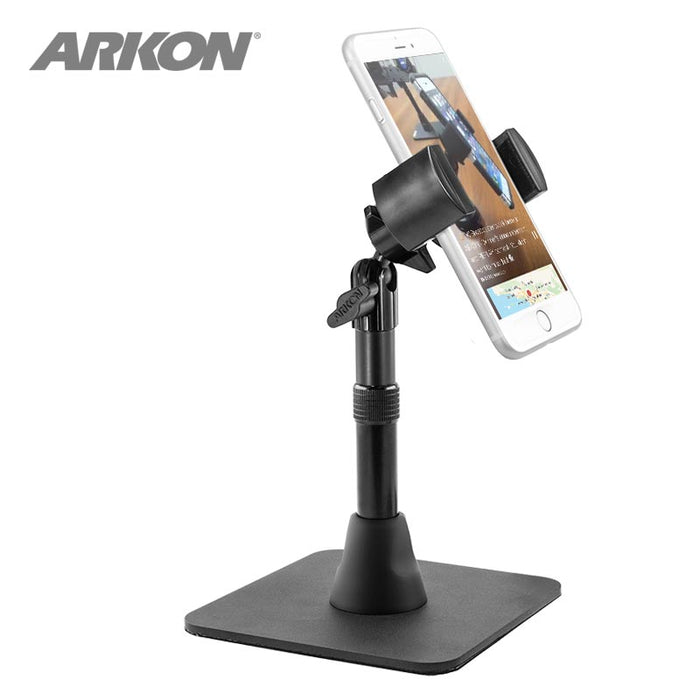 The Heavy-Duty RoadVise® Phone Stand for Live Mobile Streaming holds a smartphone vertically in a black adjustable mount with a square base, perfect for content creators. The ARKON logo appears in the top left corner.