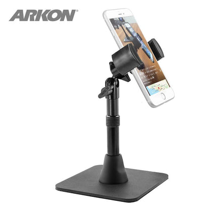 The Heavy-Duty RoadVise® Phone Stand for Live Mobile Streaming holds a smartphone vertically in a black adjustable mount with a square base, perfect for content creators. The ARKON logo appears in the top left corner.