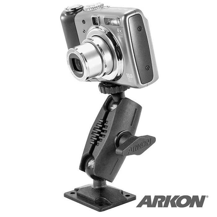 A digital camera is mounted on a Heavy-Duty Small Drill-Base Camera Mount with a 1/4-20 adapter, featuring an adjustable black design and the Arkon logo visible in the bottom right corner.