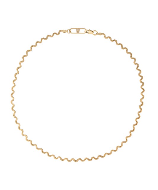 Elegant and thoughtfully designed, the WALD Berlin Irina Necklace Gold is a stunning German jewelry piece featuring a wavy gold design with a clasp. Made from graceful recycled gold, it is showcased against a black background for added allure.