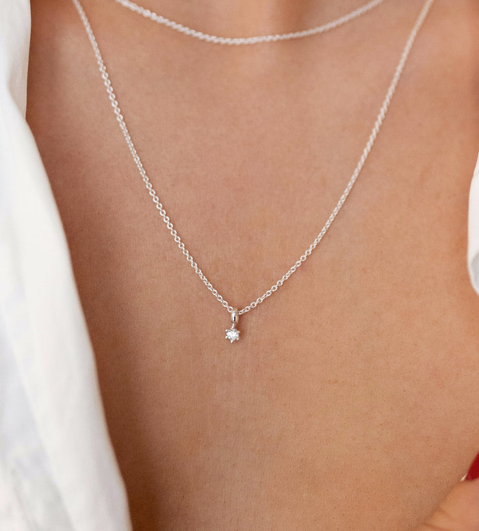 Halsband med liten gnistrande diamant i kedja.