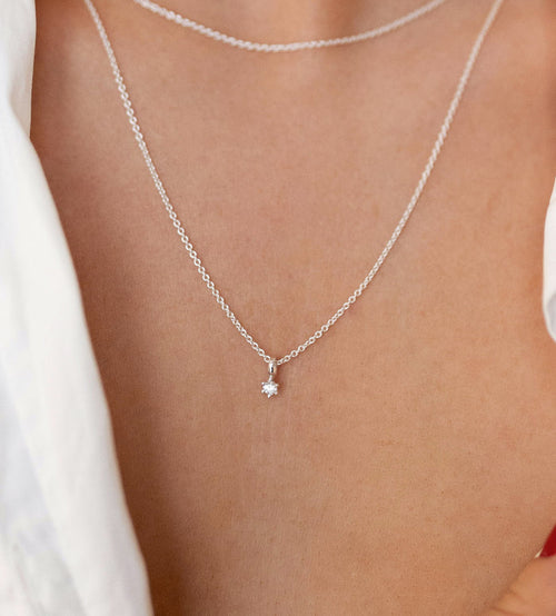 Halsband med liten gnistrande diamant i kedja.