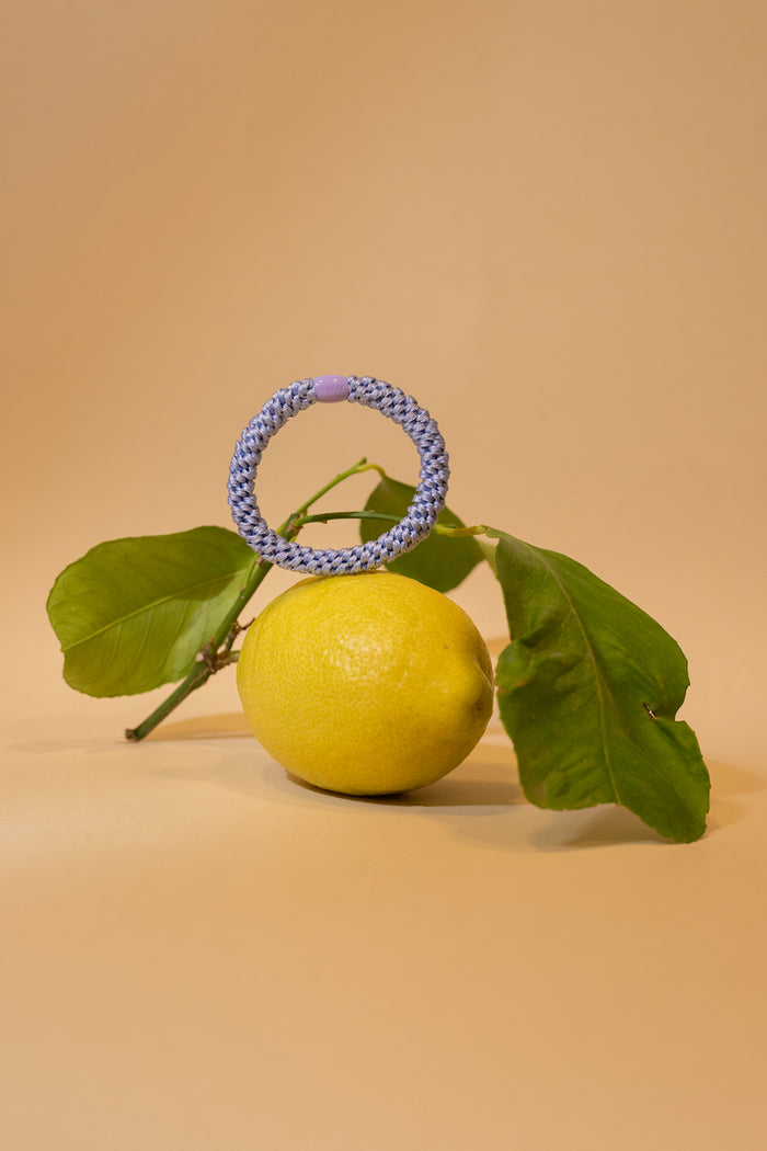 KKNEKKI Lillac braided hair tie displayed on a lemon with green leaves, shop KKNEKKI at Dotique for unique accessories.