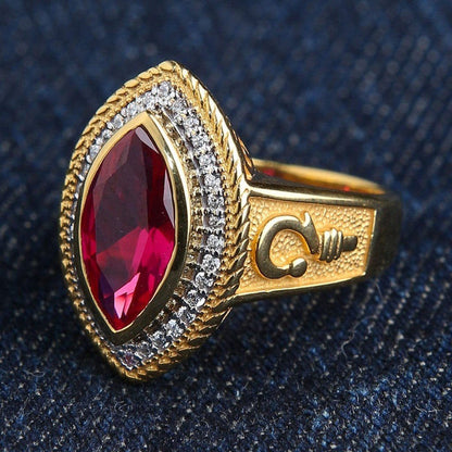 Angled view of the gold-plated Marquise Red Ruby Bishop Ring featuring a clear stone halo and crosier emblem on the band.