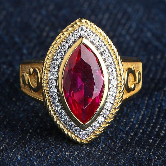 Direct top view highlighting the vibrant marquise-cut red ruby, sparkling halo, and rope-textured gold-plated setting.
