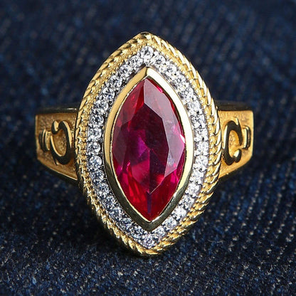 Direct top view highlighting the vibrant marquise-cut red ruby, sparkling halo, and rope-textured gold-plated setting.