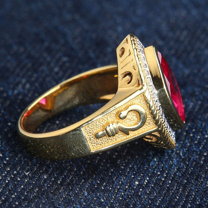 Resting on blue fabric, the gold-plated shoulder reveals a raised bishop staff emblem beneath the marquise ruby setting.
