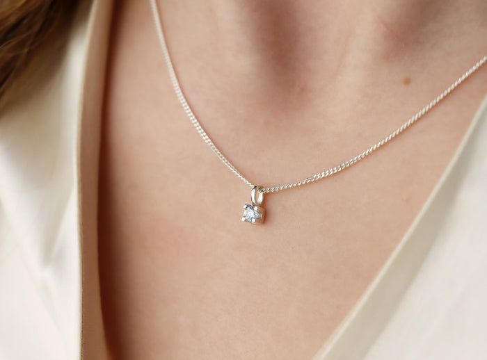 tjej som bär ett diamanthalsband i silver.