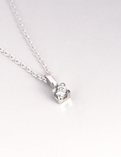 närbild på ett hängsmycke med gnistrande diamant i fyrkantig fattning.