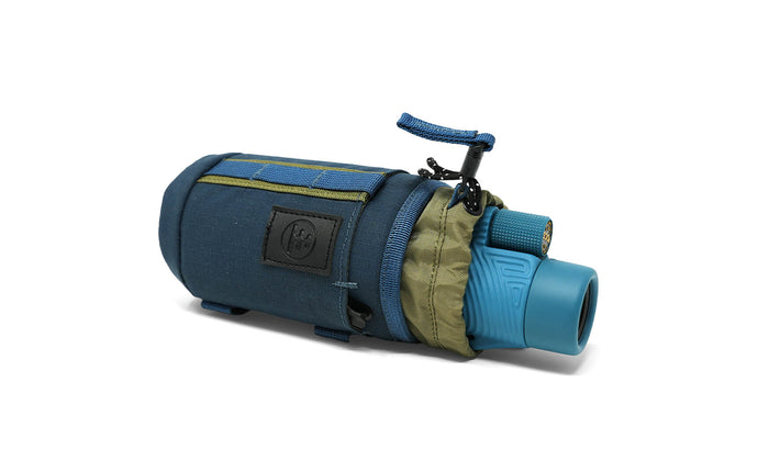 Small, versatile, and ready for more than one job, the Monocular Tube Caddy keeps your monocular protected and accessible, whether it’s slung over your shoulder, mounted to your pack, or clipped inside your car.

Featuring a drawstring cinch lid, NocLoc universal strap connectors, and rugged recycled fabric, this caddy integrates seamlessly with the NocLoc system. Bonus: it’s conveniently sized to double as a slim-can beverage holder when you’re glassing from camp or trailhead.