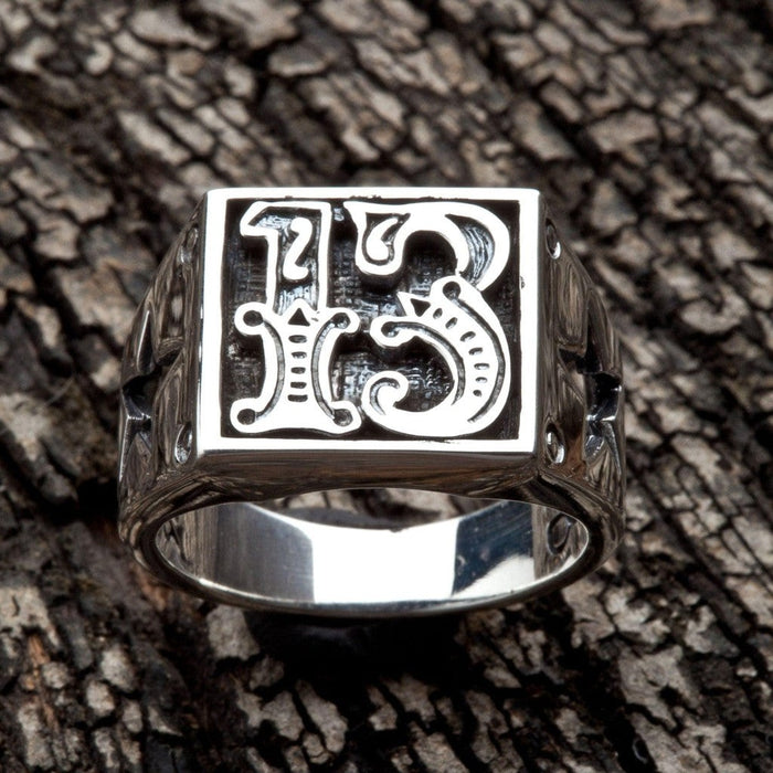 Front-facing view of raised gothic 1 and 3 numerals inside recessed oxidized panel on sterling silver ring