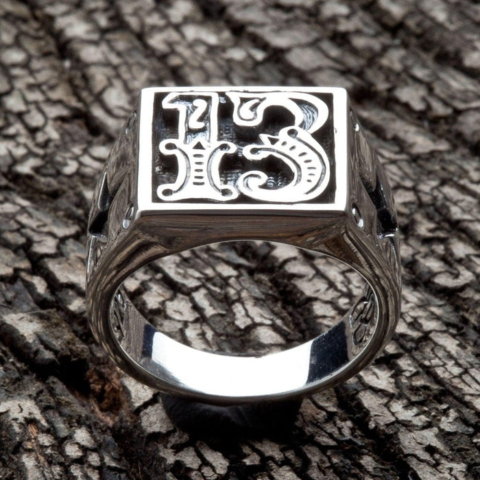 Straight-on view highlighting deep hand-applied oxidation behind the gothic 13 numerals