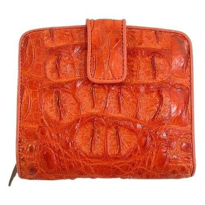 Snap tab closure detail on burnt-orange crocodilian hornback wallet showing deep papaya-amber raised scale texture