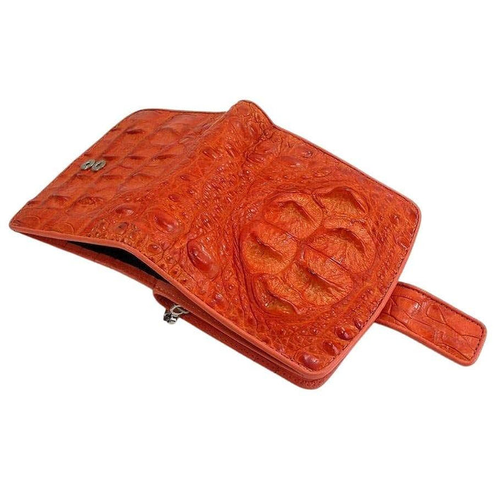 Open flap view of burnt-orange crocodilian hornback wallet revealing magnetic snap closure and raised crown scale texture