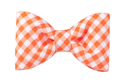 A bright orange and white gingham bow tie for dogs, with neatly curved edges and a gathered center. The soft cotton fabric adds comfort, while the cheerful plaid print brings playful charm to everyday outings.