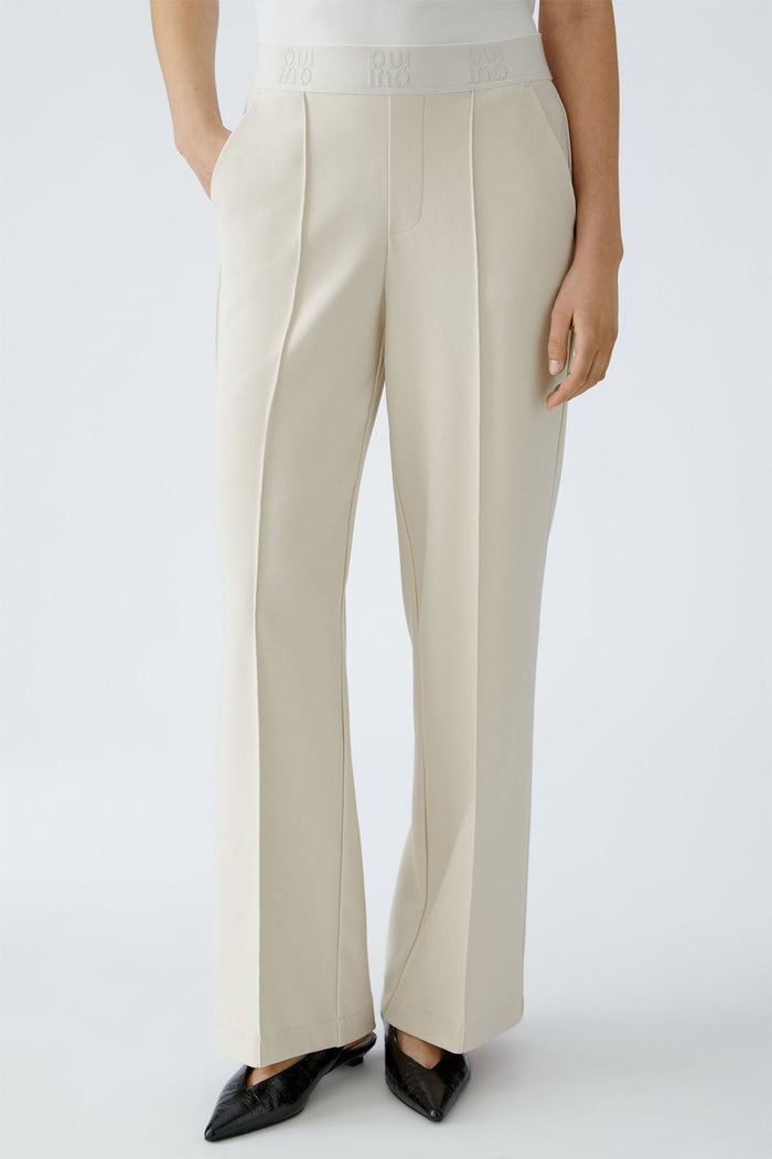 Beige pants worn by a person on a white background