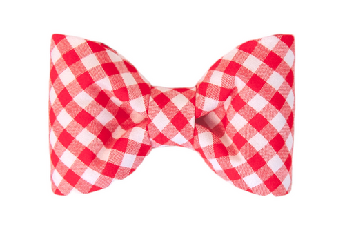 Red plaid dog bow tie with a crisp checkered pattern in alternating squares. The bow tie comes together in the middle  with a tightly cinched center, and has gently curved sides, giving it a balanced, tailored appearance suitable for everyday wear or special occasions.