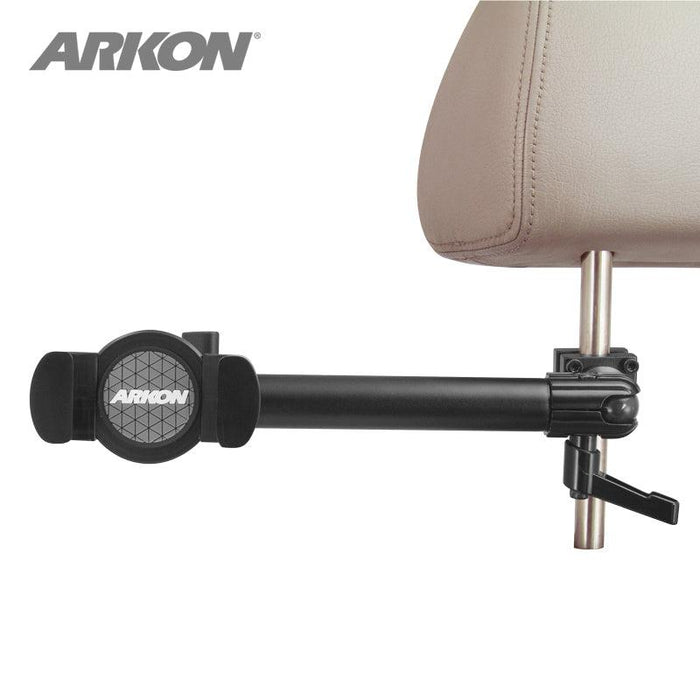 A black RoadVise® Phone Holder with Car Headrest Mount attaches to a tan seat headrest post using adjustable clamps and an extending arm, ideal for backseat entertainment. The Arkon logo is visible on the holder.