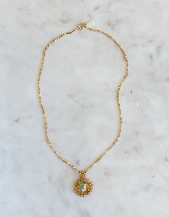 The WALD Berlin Sample saleSay My Name Gold Necklace features a gold-plated chain with a round turquoise and gold letter "J" pendant, displayed on light marble—a stylish initial necklace for any occasion.