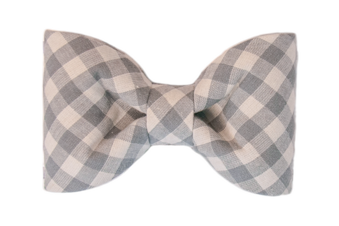 Large bow tie made from soft woven fabric in a light gray gingham plaid pattern, featuring two wide, rounded loops symmetrically gathered at the center. The perfect addition to your dog's fall wardrobe.
