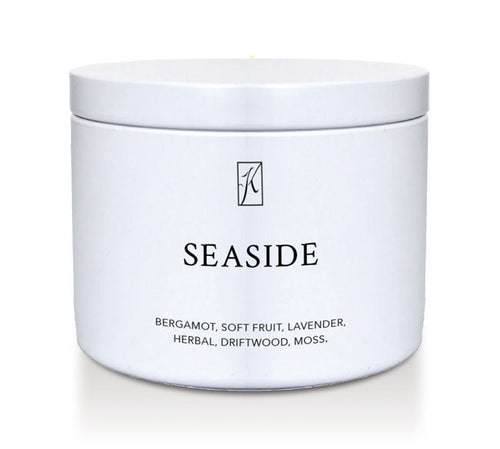 White tin candle container labeled 'Seaside' with a brand logo on a white background