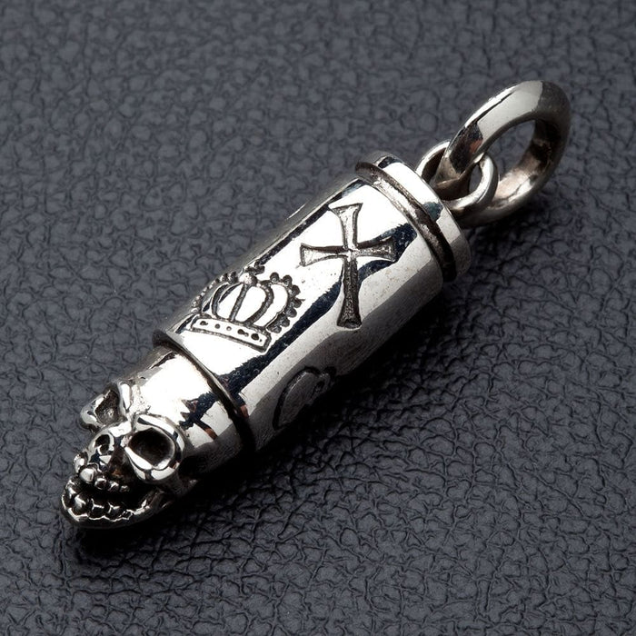 A close-up view of the silver skull bullet pendant, showing the detailed and oxidized royal crown engraving.