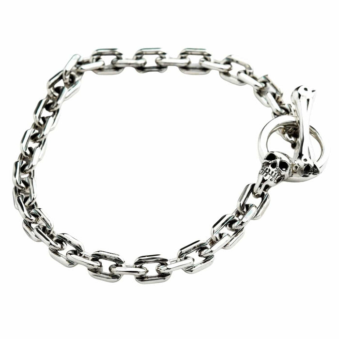 Angled view of the men's silver chain bracelet with a skull and bone T-bar clasp.