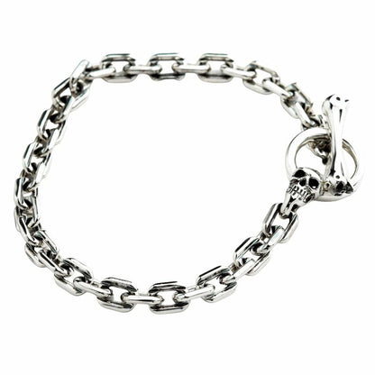 Angled view of the men's silver chain bracelet with a skull and bone T-bar clasp.