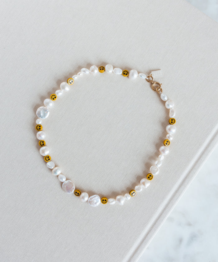 A Smilie Dude Pearl Necklace from WALD Berlin on top of a book in Germany.