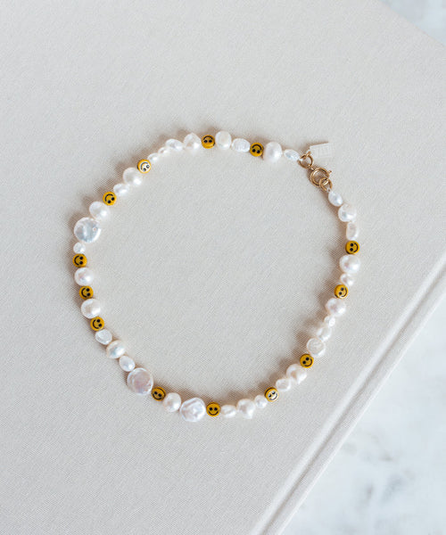 A Smilie Dude Pearl Necklace from WALD Berlin on top of a book in Germany.